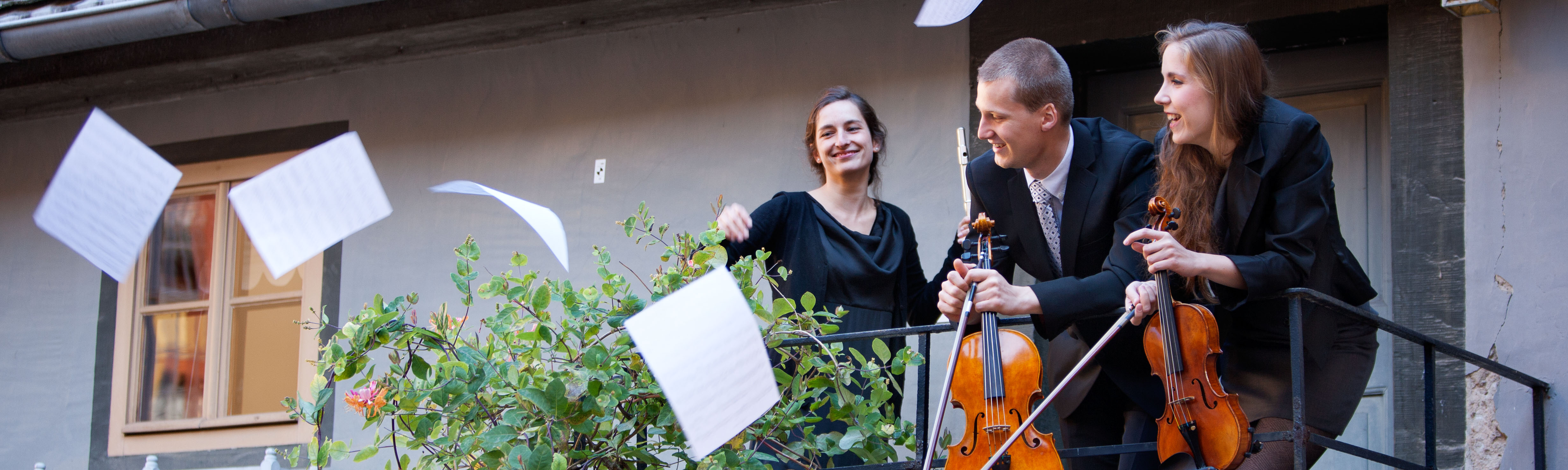 The picture shows musicians with sheets of music.