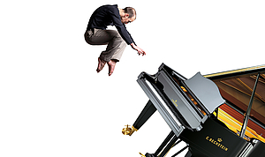 The image shows a man floating above a concert grand piano.