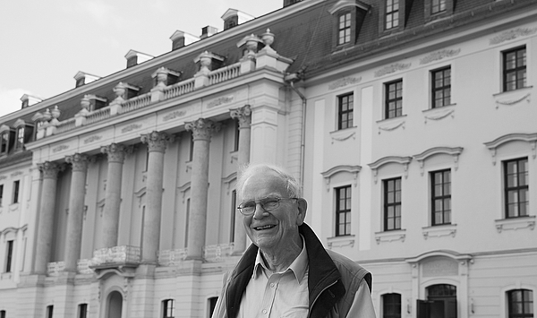 Das Bild zeigt einen Mann vor einem historischen Gebäude.