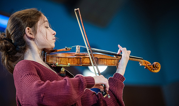 Das Bild zeigt eine junge Frau mit einer Violine.