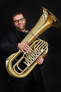 Das Bild zeigt einen Mann mit einer Tuba.