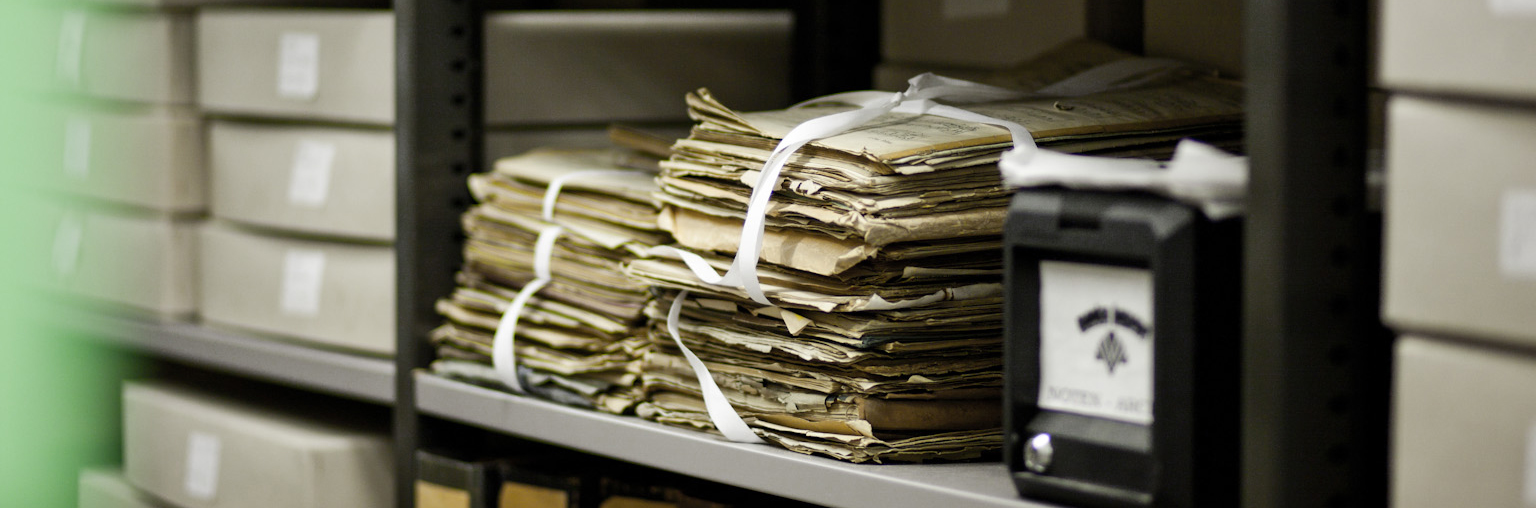 The picture shows archive material on a shelf.