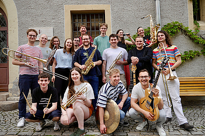 The picture shows young people with instruments.