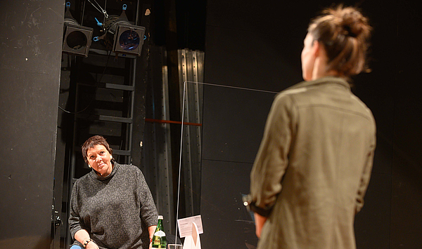 Das Bild zeigt links eine Frau mit dunklen Haaren und rechts eine rothaarige Frau mit dem Rücken zum Betrachter. Das Bild zeigt links eine Frau mit dunklen Haaren und rechts eine rothaarige Frau mit dem Rücken zum Betrachter.