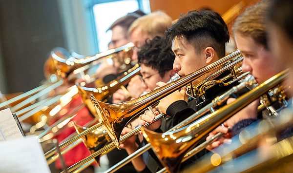 Das Bild zeigt mehrere Menschen mit Posaunen.