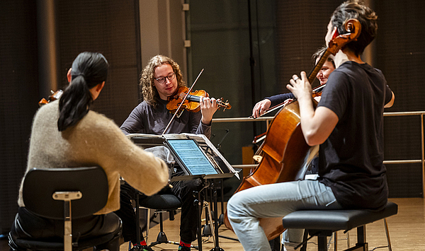 Das Bild zeigt vier Musiker auf einer Bühne.