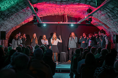 Das Foto zeigt Menschen mit Mikrophon.