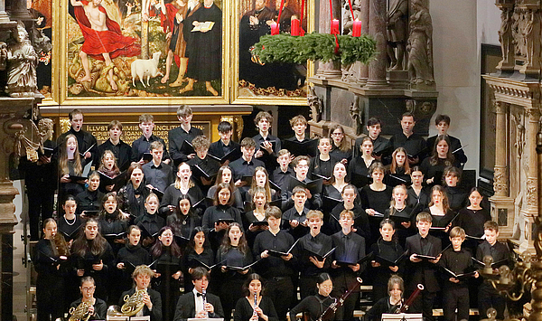 Das Bild zeigt Sänger*innen vor einem Altar.