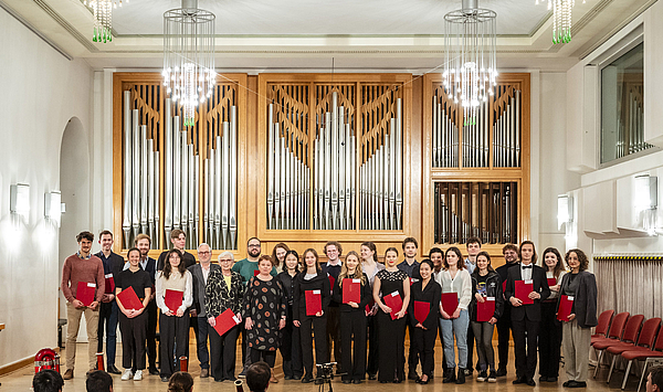 Das Bild zeigt eine Gruppe von Studierenden auf einer Bühne. Das Bild zeigt eine Gruppe von Studierenden auf einer Bühne.
