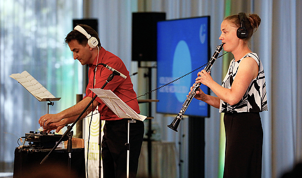 Das Foto zeigt einen Mann mit Kopfhörern und eine Frau mit Klarinette.