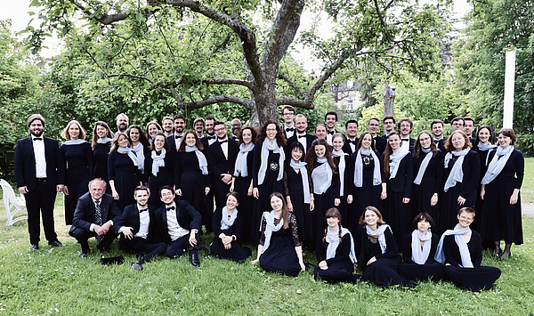 Das Bild zeigt eine Gruppe von Menschen auf einer Wiese. 