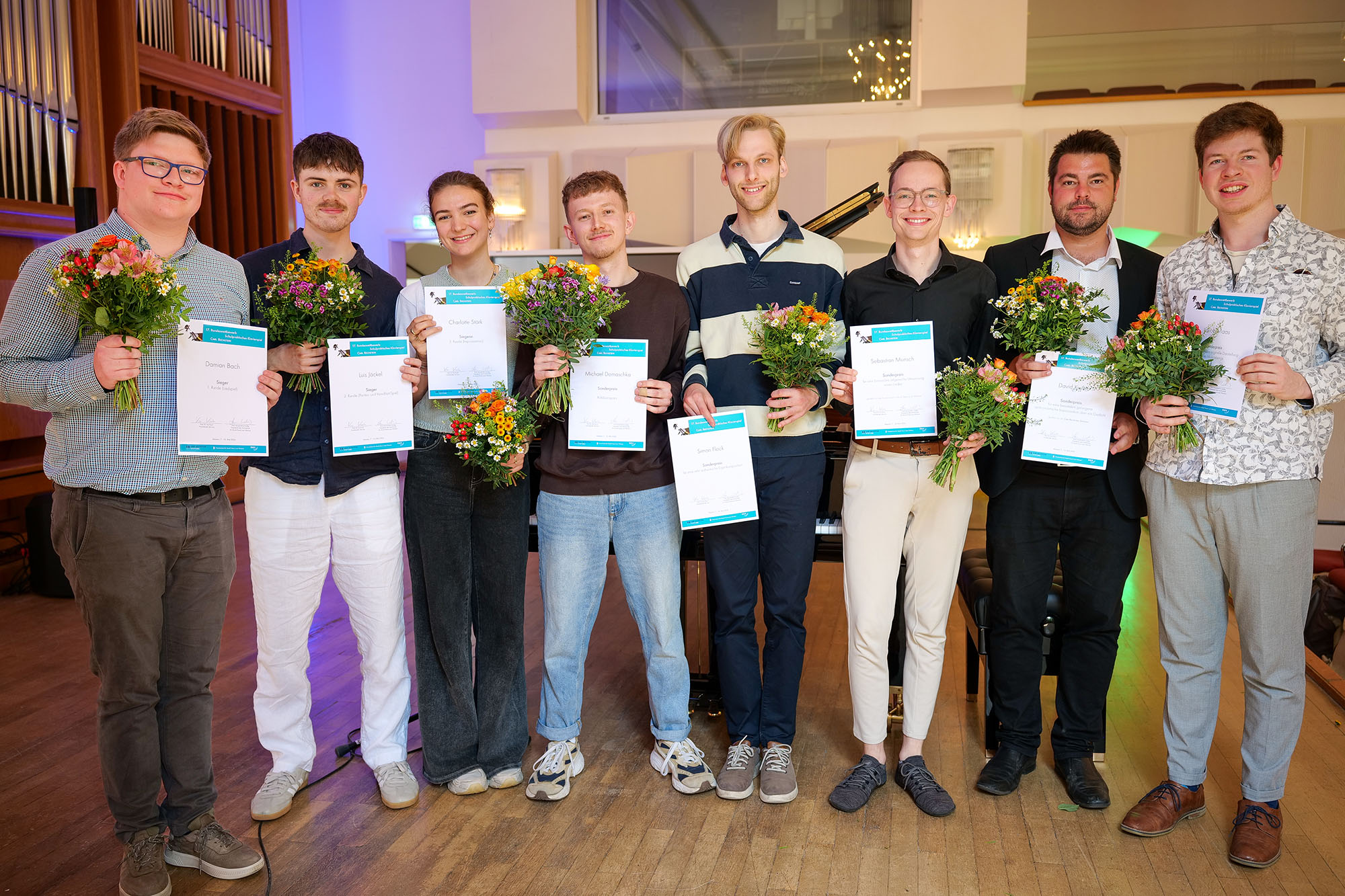 Das Bild zeigt eine Gruppe von Menschen mit Urkunden.