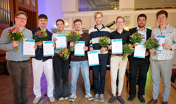 Das Bild zeigt eine Gruppe von Menschen mit Urkunden.