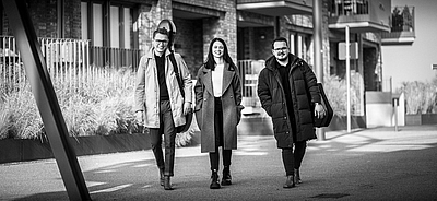 Das Bild zeigt drei Musiker*innen auf einer Straße.