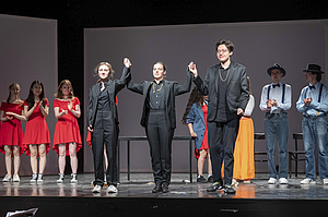 The picture shows many people on a stage.