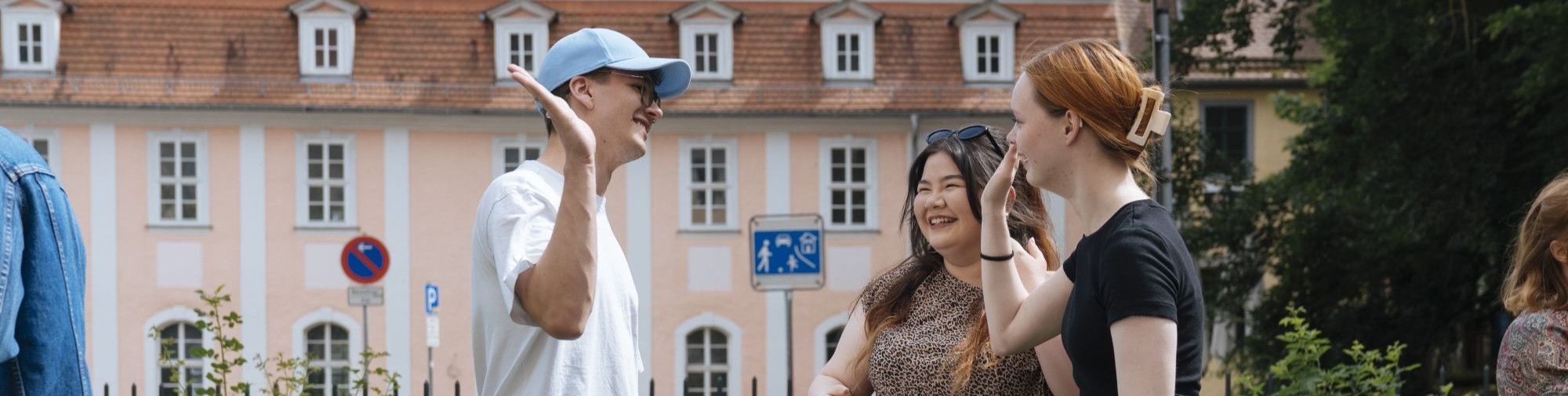 Das Bild zeigt drei lachende Menschen.