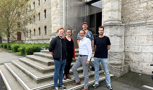 Das Bild zeigt fünf Personen auf einer Treppe.