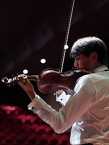 The picture shows a young person with a violin.